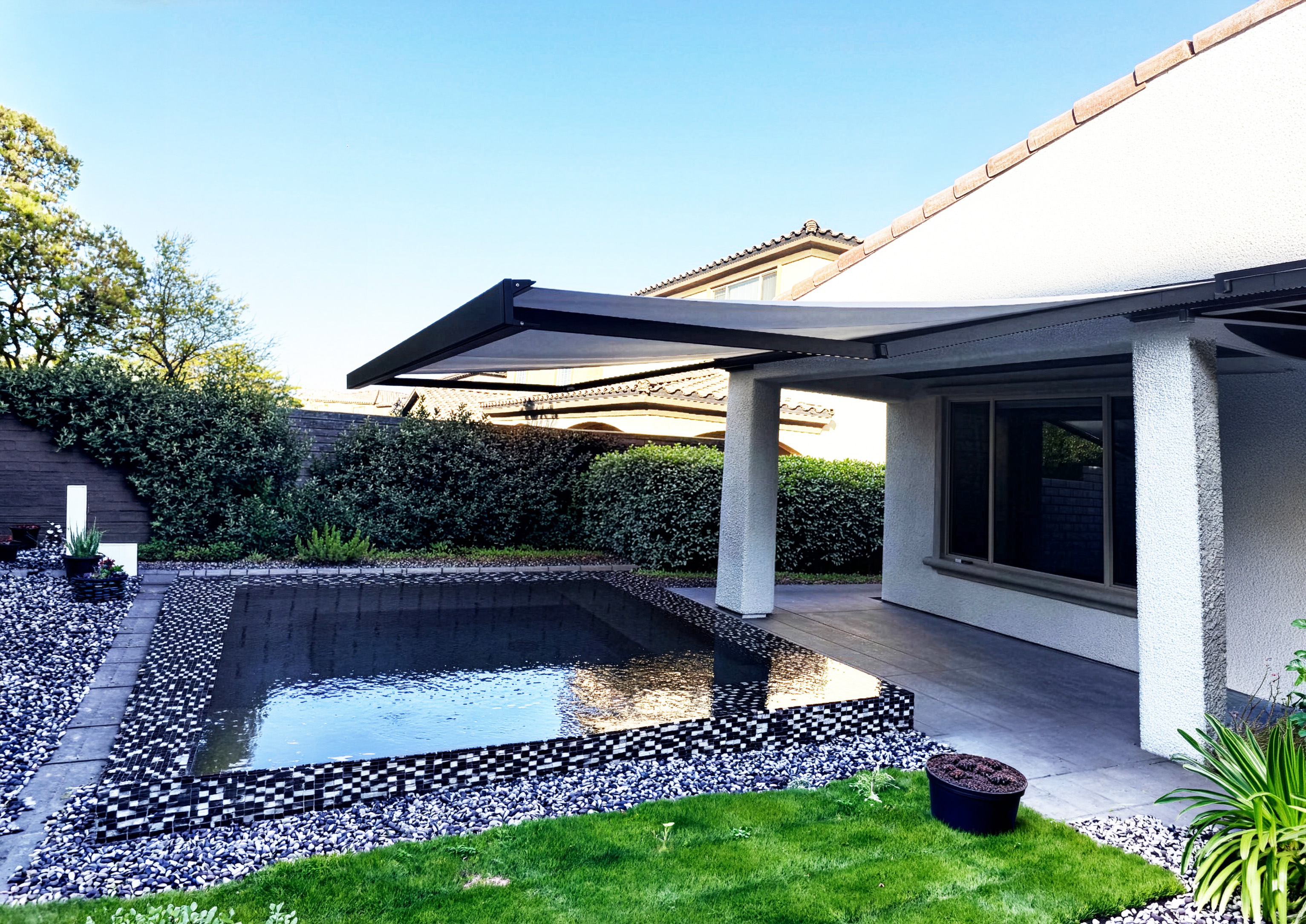 Retractable shade over modern pool area
